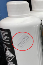 Batch number sticker on bottle side